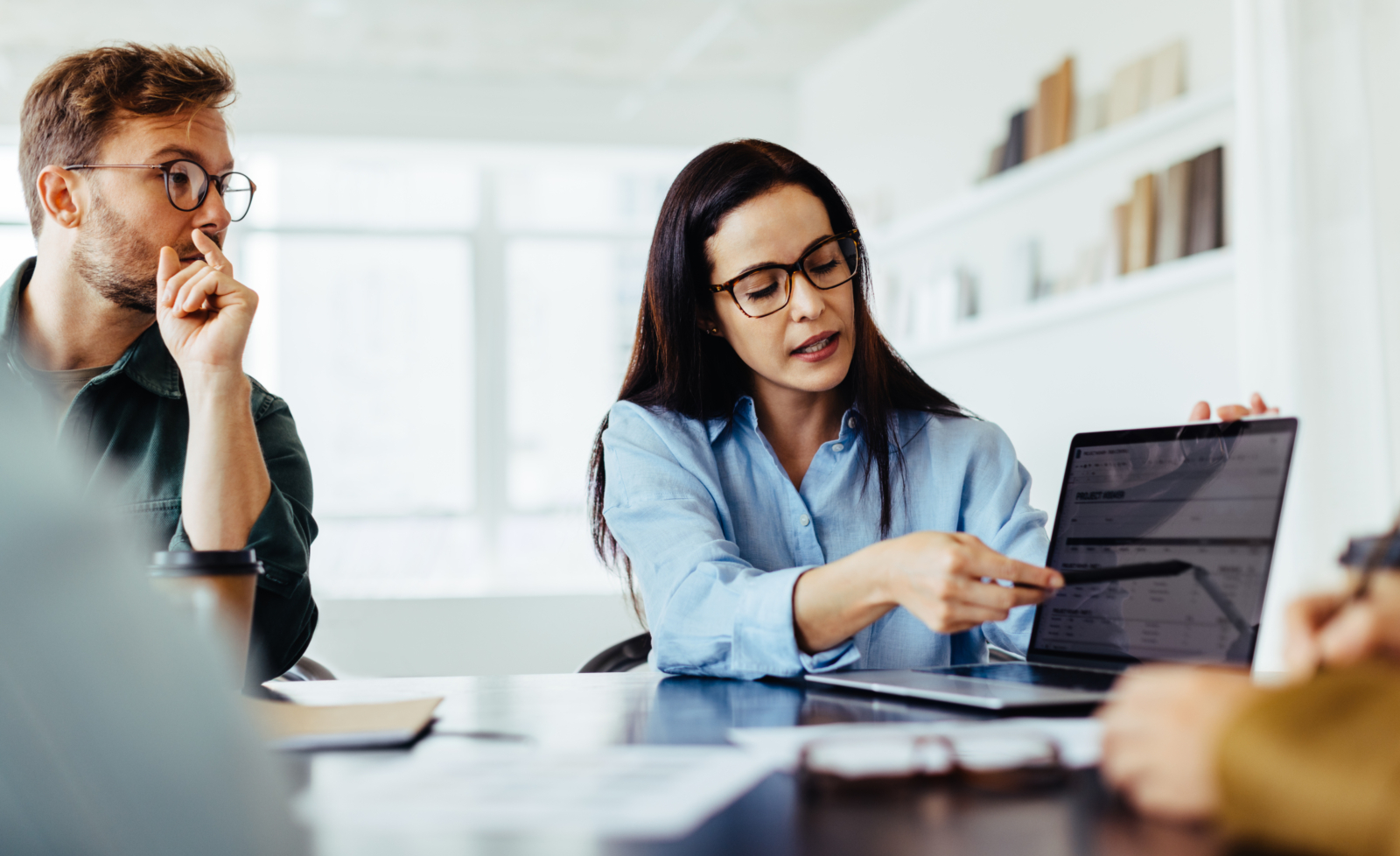 Business woman discussing a project report with her team in an office